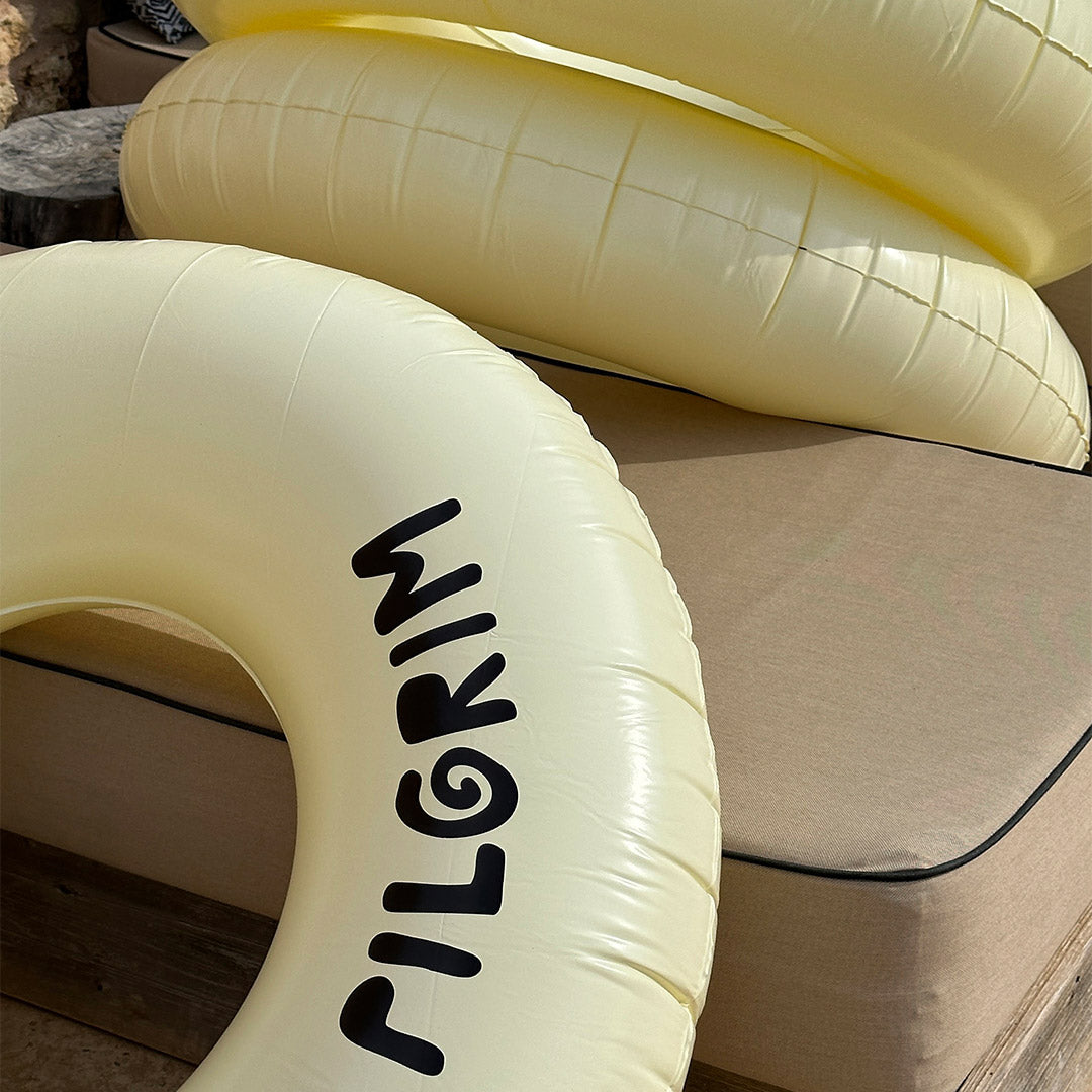 Off-white swim ring, 120 cm, featuring a sleek black Pilgrim logo, perfect for stylish summer relaxation by the pool or beach.