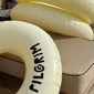 Off-white swim ring, 120 cm, featuring a sleek black Pilgrim logo, perfect for stylish pool or beach lounging.