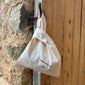 Close-up of the Small Fashion canvas tote-bag in off-white, featuring broad woven straps and wherever you go print, embodying Pilgrim's minimalist and sustainable design.