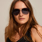 NANI pilot sunglasses with bluish lenses and silver-plated frame on a woman, showcasing their avant-garde style and 70s-inspired design.
