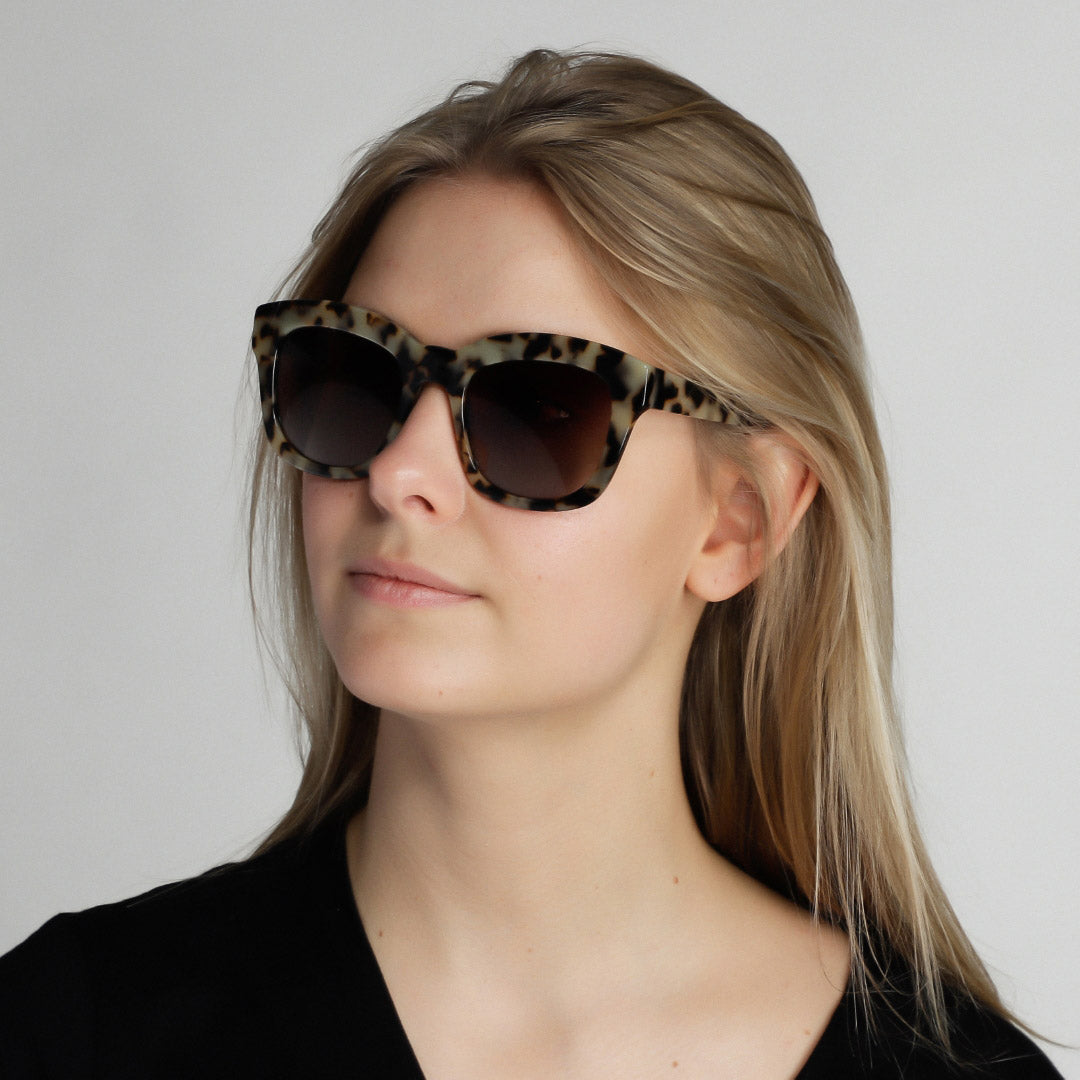 Dael sunglasses with chunky butterfly-shaped frame worn by a woman, offering UVA/UVB protection and a trendy, retro-inspired look.