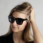 Dael sunglasses feature a chunky butterfly frame worn by a woman, embodying a trendy and cool look with full UVA/UVB protection.