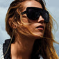 Woman wearing sunglasses with a gold-plated CAT chain from Pilgrim, featuring a simple yet glamorous pattern, perfectly complementing Pilgrim eyewear.