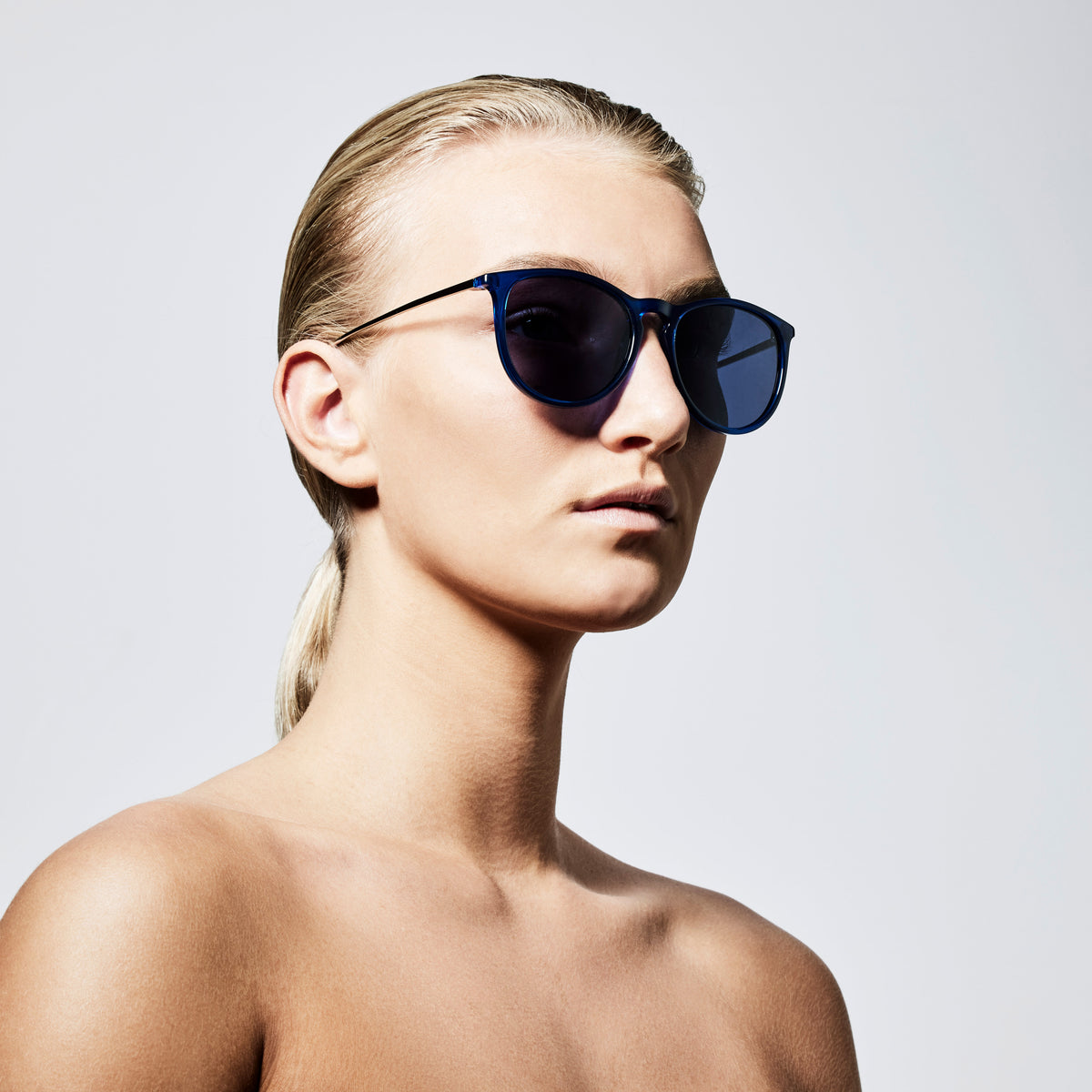 Woman wearing VANILLE sunglasses in dark blue with silver-plated frames, showcasing Pilgrim's blend of timeless style and modern protection.