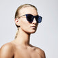 Woman wearing VANILLE sunglasses in dark blue with silver-plated frames, showcasing Pilgrim's blend of timeless style and modern protection.