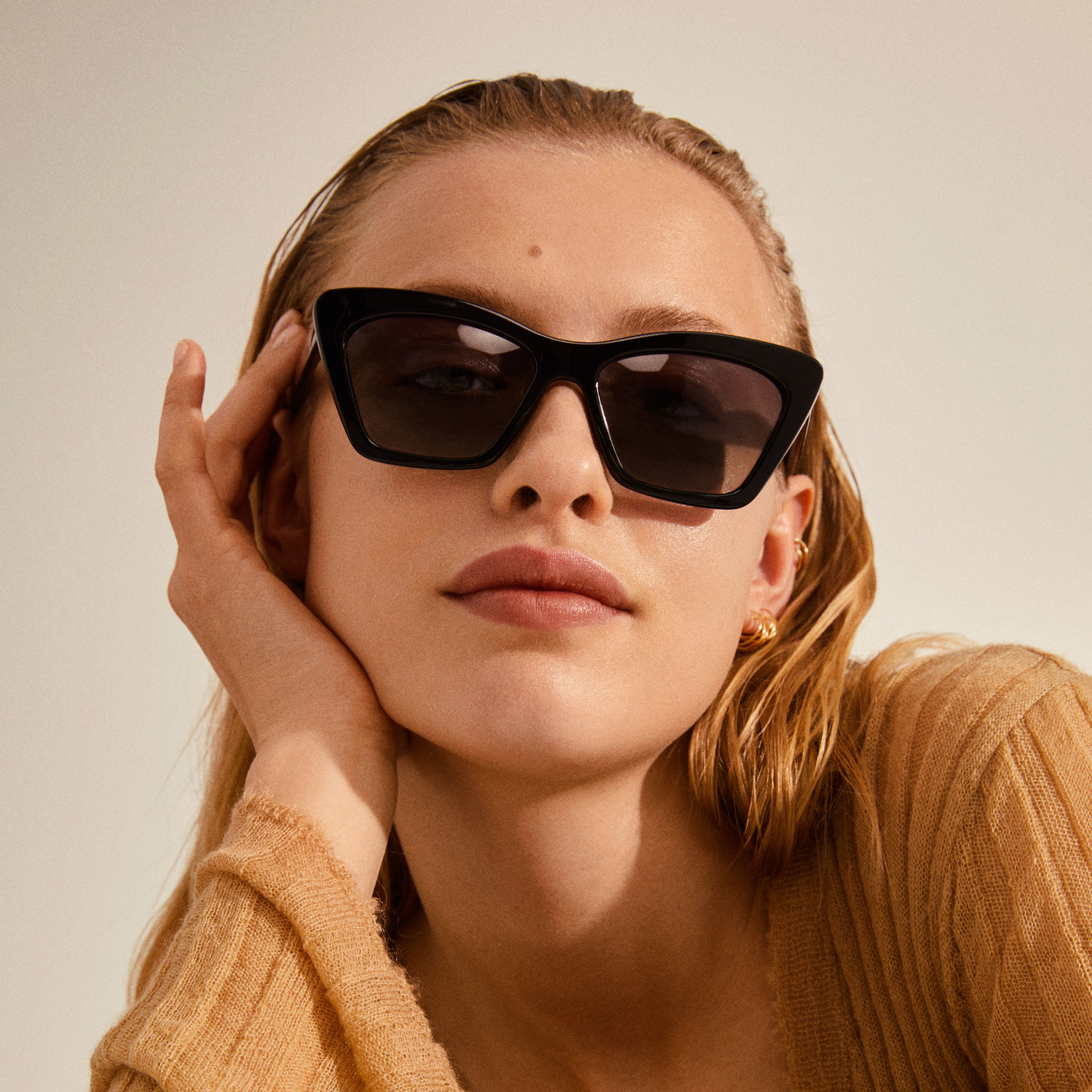Woman wearing Pilgrim's DAKOTA angular cat-eye sunglasses, showcasing a classic, feminine look with elegant eyewear.