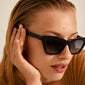 DAKOTA angular cat-eye shaped sunglasses black worn by a woman, highlighting the elegant and feminine design with a stylish, timeless appeal.