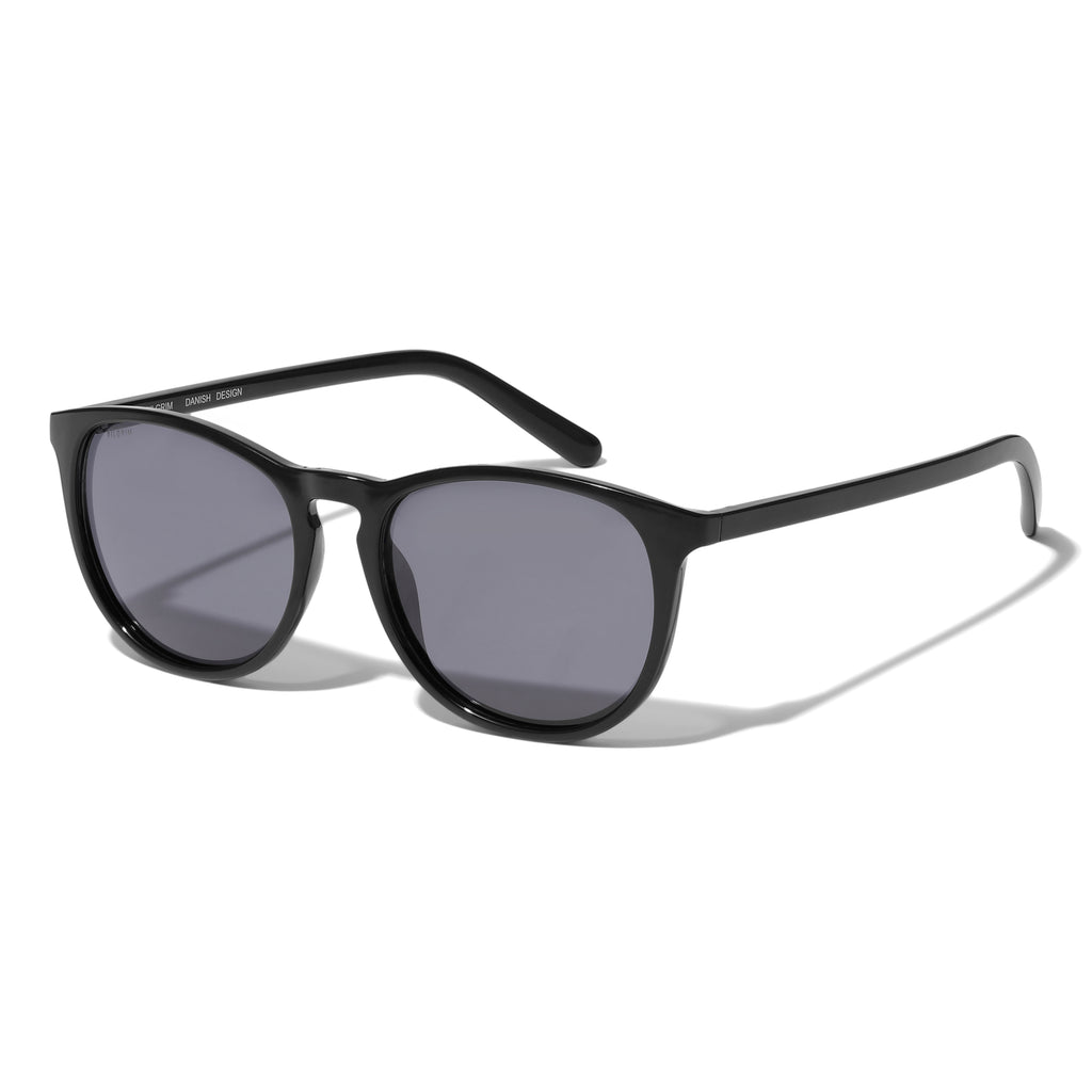 CAMILLA light frame sunglasses in black, featuring a classic design made from 75% recycled ocean plastic with narrow temples and smoky lenses.