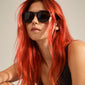 CAMILLA sunglasses featuring a classic, lightweight frame made from recycled ocean plastic, worn by a woman with red hair and a relaxed style.