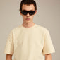 A man wearing GERTRUD sunglasses by Pilgrim, showcasing the trendy arched frames that combine classic design with a modern edge.