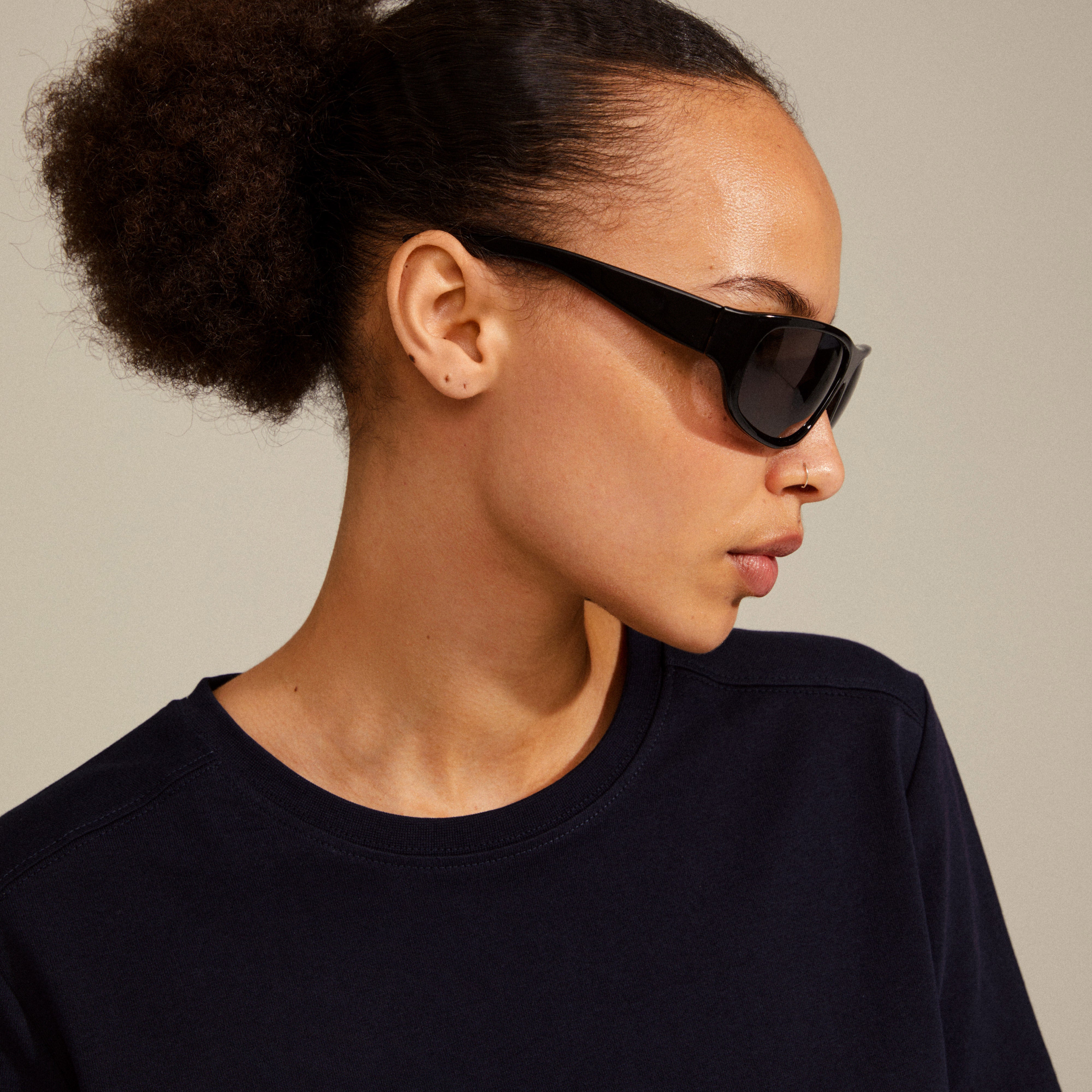 Woman wearing GERTRUD sunglasses by Pilgrim, showcasing a classic design with arched frames, embodying a blend of timeless style and modern edge.