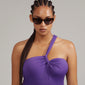 JUNA cat-eye sunglasses featuring a brown tortoiseshell frame and graduated lenses, worn by a woman with braided hair, exuding retro-inspired elegance.