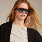 YARIL sunglasses in tortoise brown, worn by a woman, feature light blue lenses. A stylish accessory offering UVA/UVB protection, ideal for summer fashion.