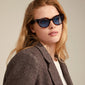 Woman wearing Raisa sunglasses, showcasing their timeless cat-eye shape and elegance, made from recycled plastic with UV protection from Pilgrim.