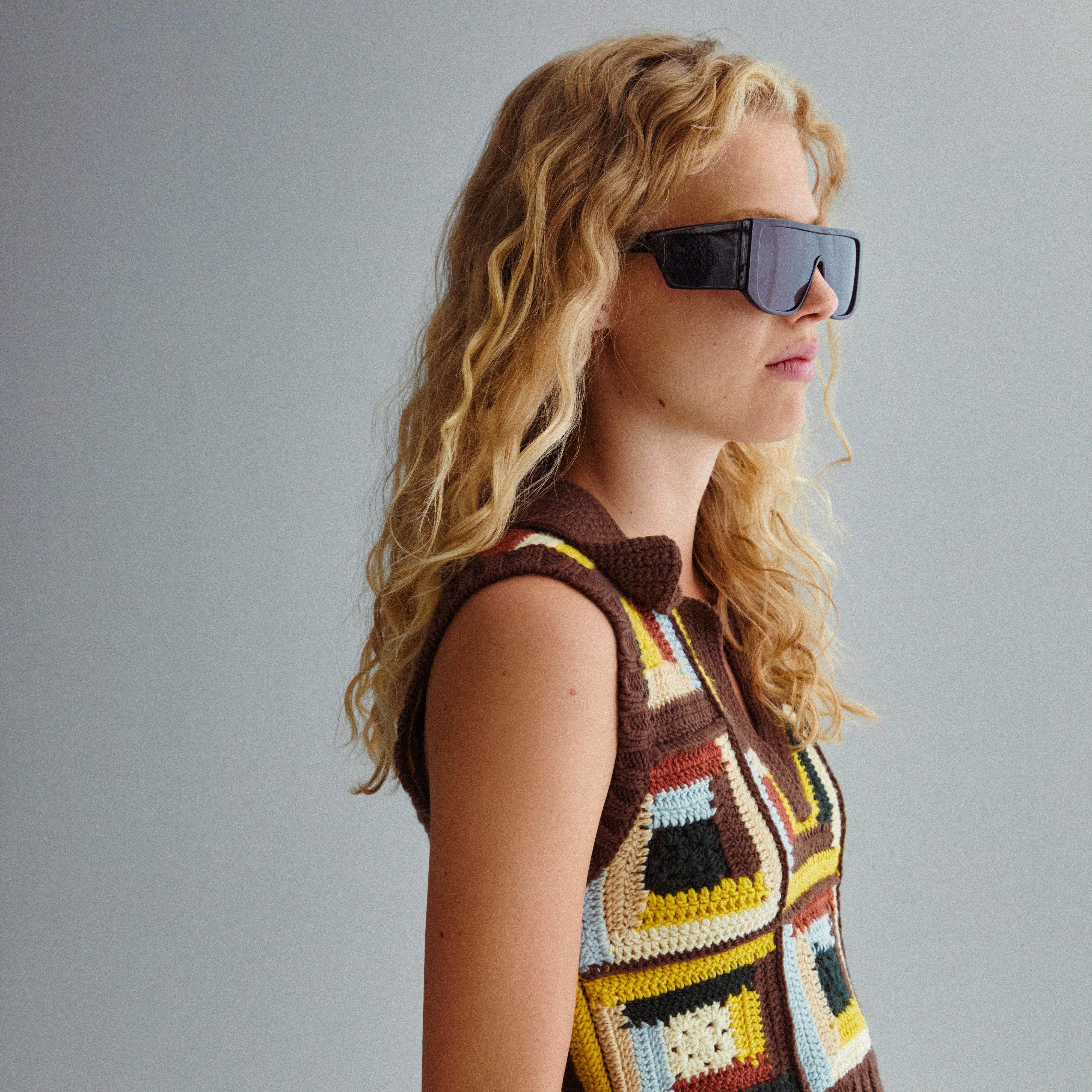 Woman wearing JOHARI sunglasses with black oversized frames, showcasing trendy L.A. style. Features UVA/UVB protection and sustainable materials from Pilgrim.