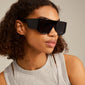 Johari sunglasses black, oversized frames with dark lenses and broad temples, embody trendy L.A. vibes, ideal for sunbathing or socializing.