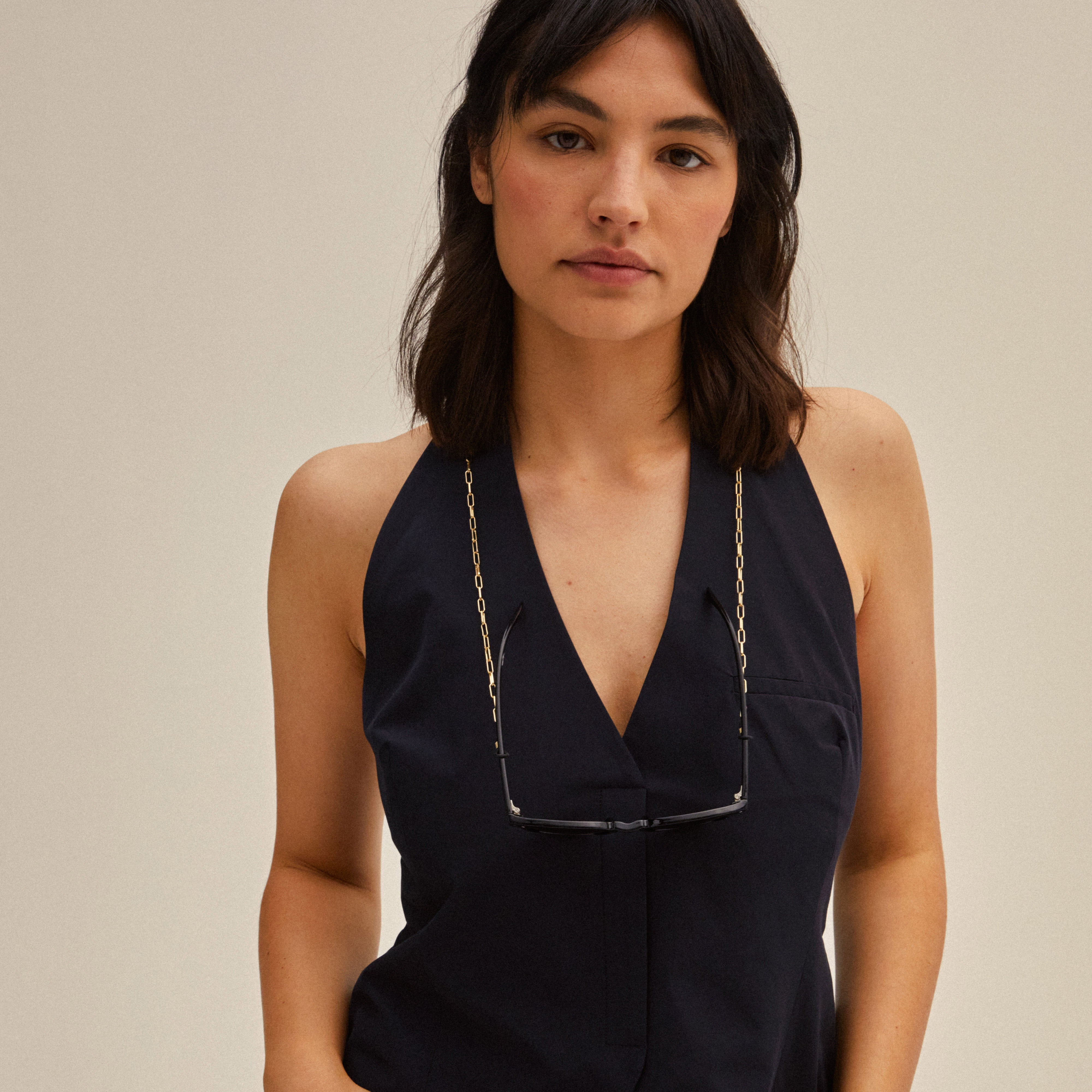 Woman models PAOLA gold-plated chain for sunglasses by Pilgrim, featuring delicate cable-chain design, enhancing eyewear with stylish, modern flair.