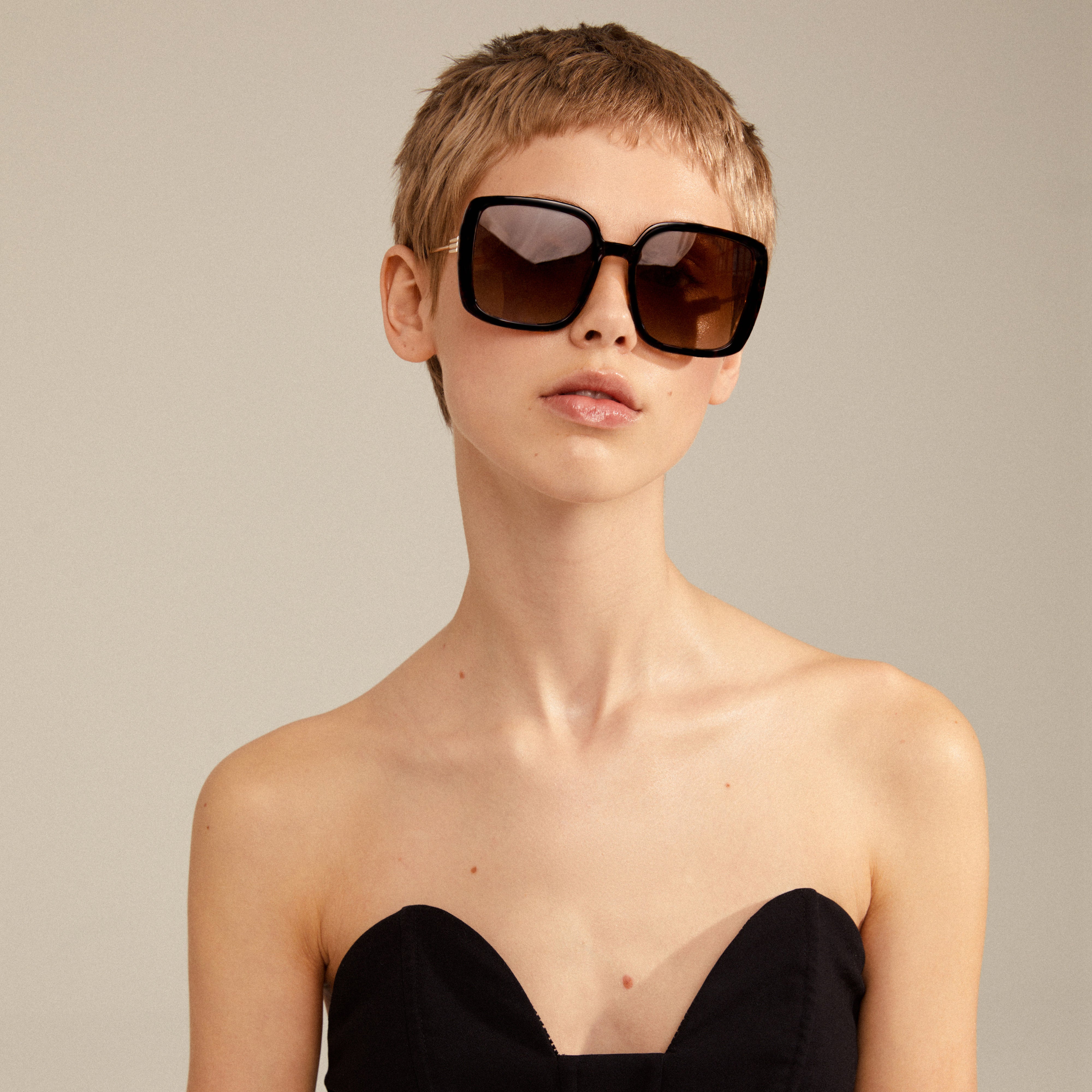 Woman with short hair wearing Aliet sunglasses, showcasing their oversized design and trendy vintage-inspired look, perfect for elevating springtime fashion with bold styling.