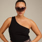 ALIAN sunglasses black/gold featuring a futuristic single lens design, worn by a woman with dark sunglasses and a black tank top, exuding urban style.