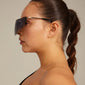 Woman wearing Pilgrim's ALIAN sunglasses with a futuristic single lens design, embodying empowerment and urban style.