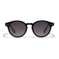 Kyrie sunglasses in black with a round shape, featuring a gold-studded rim. Offers UVA/UVB protection and includes a sustainable pouch.