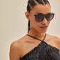 Woman wearing VANILLE sunglasses with stylish metal temples and soft rounded lenses, showcasing a chic, versatile accessory from Pilgrim.