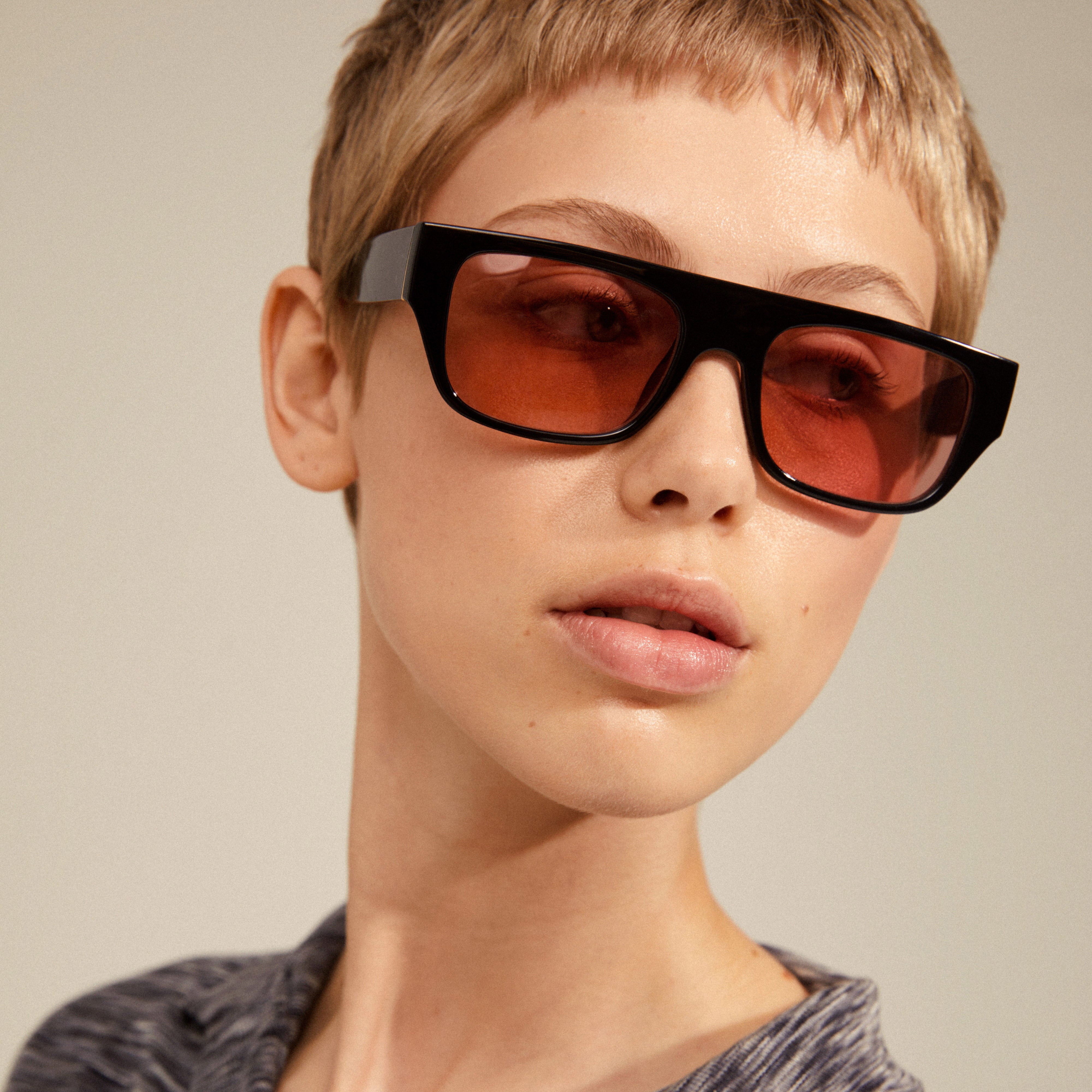 ENIEL sunglasses black/gold featuring trendy orange lenses, worn by a woman with short hair, exemplify Pilgrim's blend of classic style and modern design.