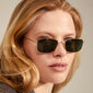 Woman wearing YEIDER sunglasses green/gold, showcasing the classic 70s-inspired design with dark green lenses, perfect for stylish personal expression.