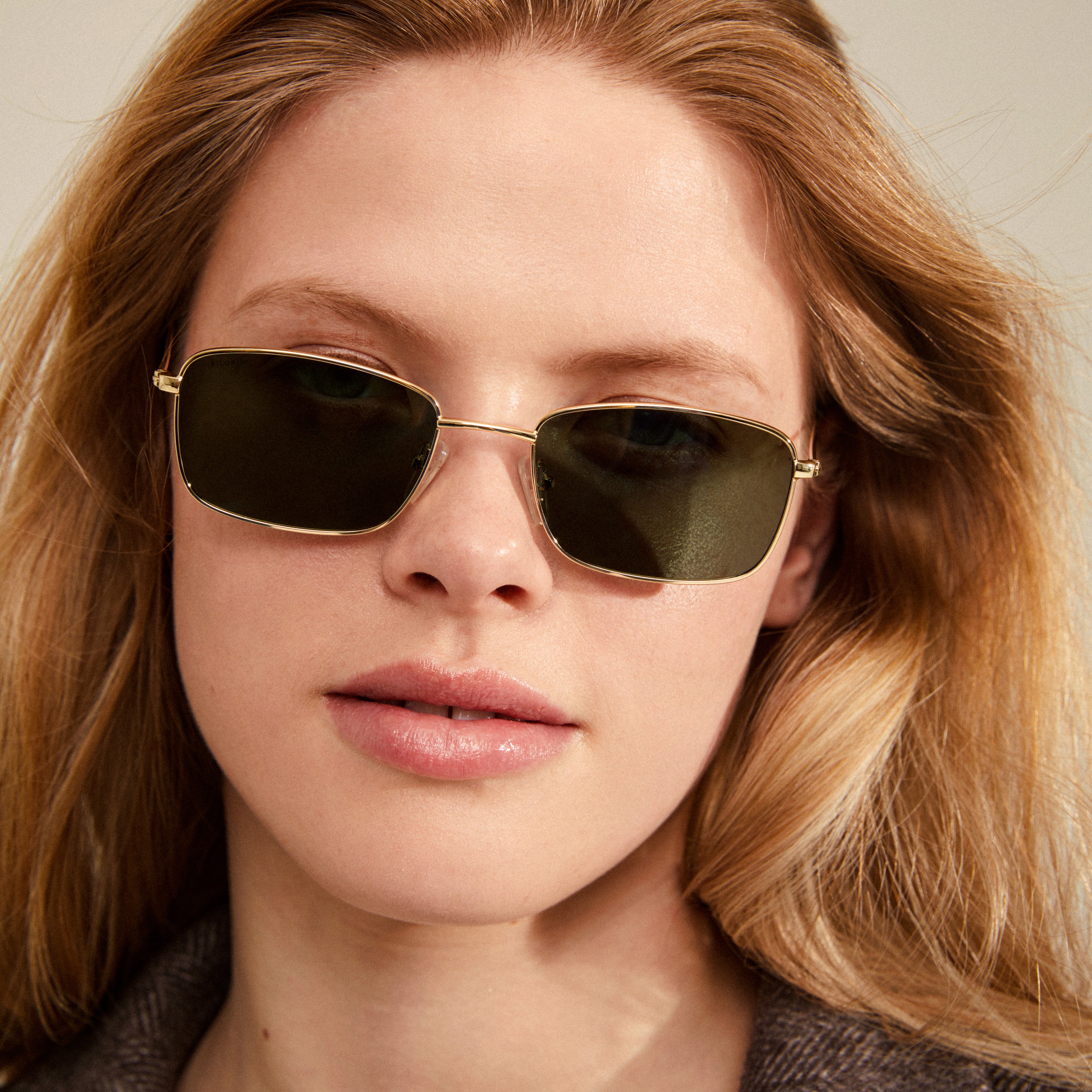 YEIDER sunglasses in gold with dark green lenses, worn by a woman, embody a retro 70s vibe with UVA/UVB protection.