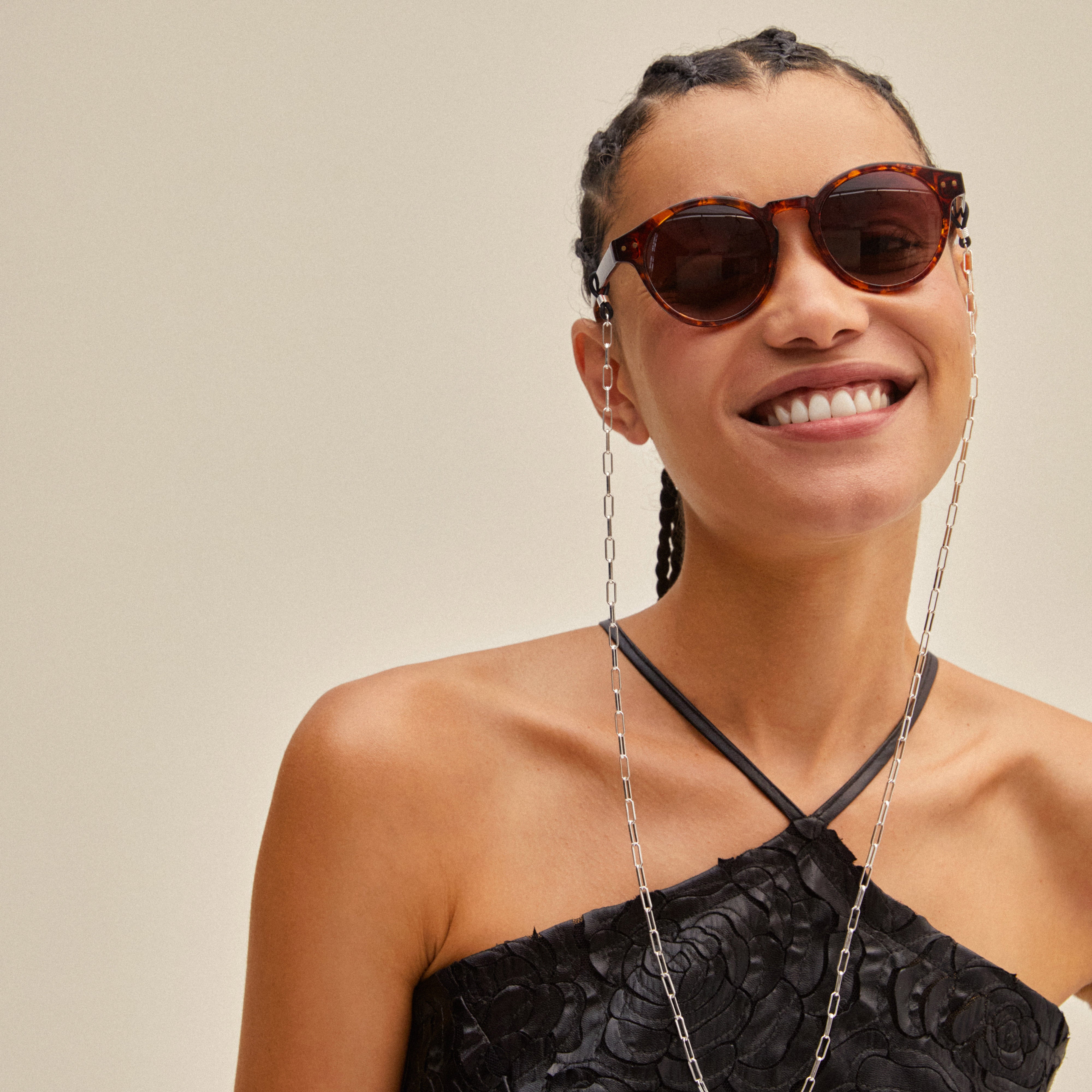 Woman wearing KYRIE sunglasses in tortoise brown/gold, showcasing Pilgrim's stylish eyewear with a necklace, highlighting Scandinavian quality and summer fashion.