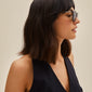 VANILLE sunglasses with tortoise frames and golden temples, worn by a woman in a black dress, exude timeless elegance and sporty style.