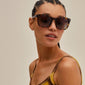 KATYA sunglasses: tortoise-brown frames with graduated lenses, worn by a woman, offering UVA/UVB protection. Perfect for a stylish, sustainable summer look.