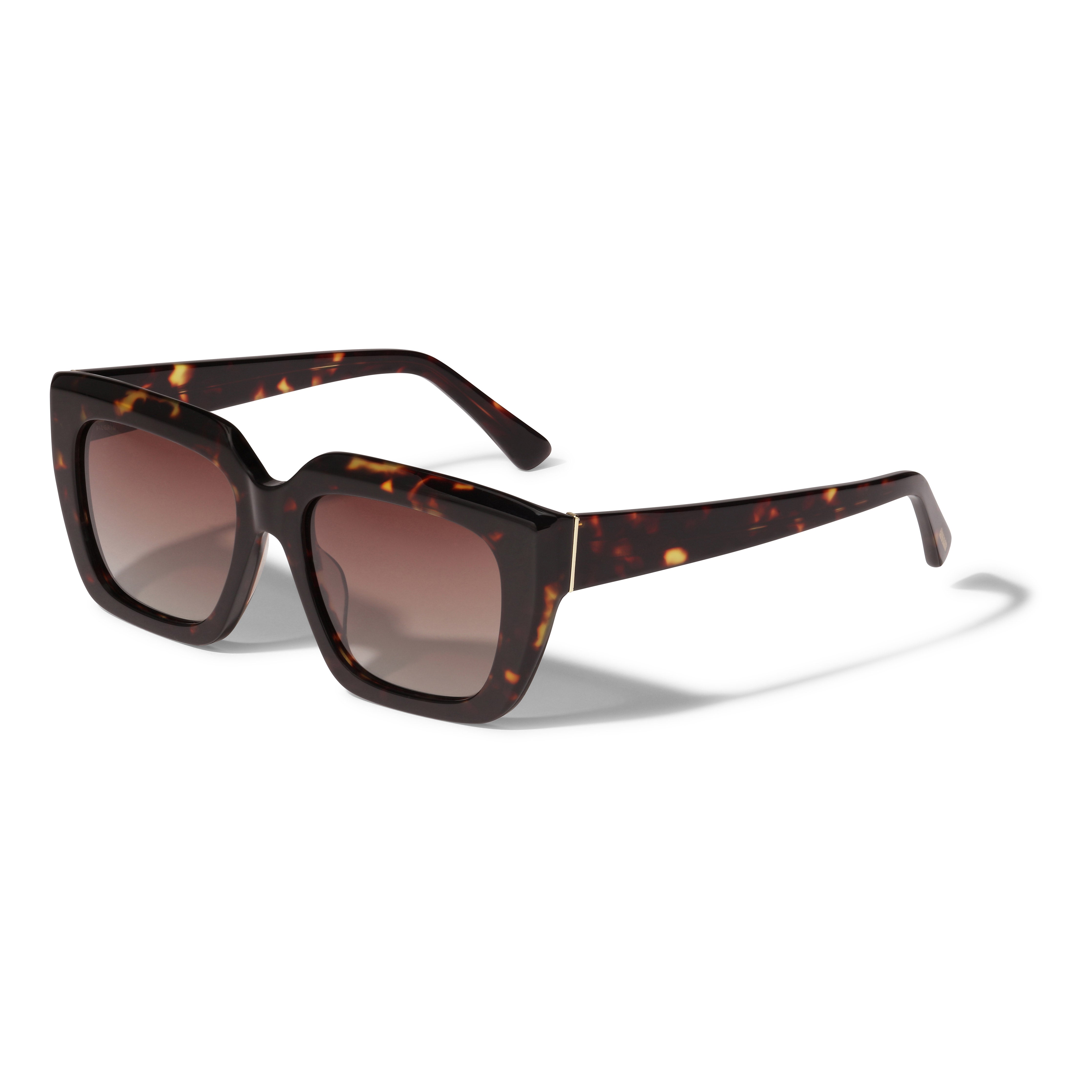 JOGLI sunglasses feature an oversized design with sharp frames, golden hinge details, and brown lenses. Made from recycled acetate by Pilgrim, offering UVA/UVB protection.