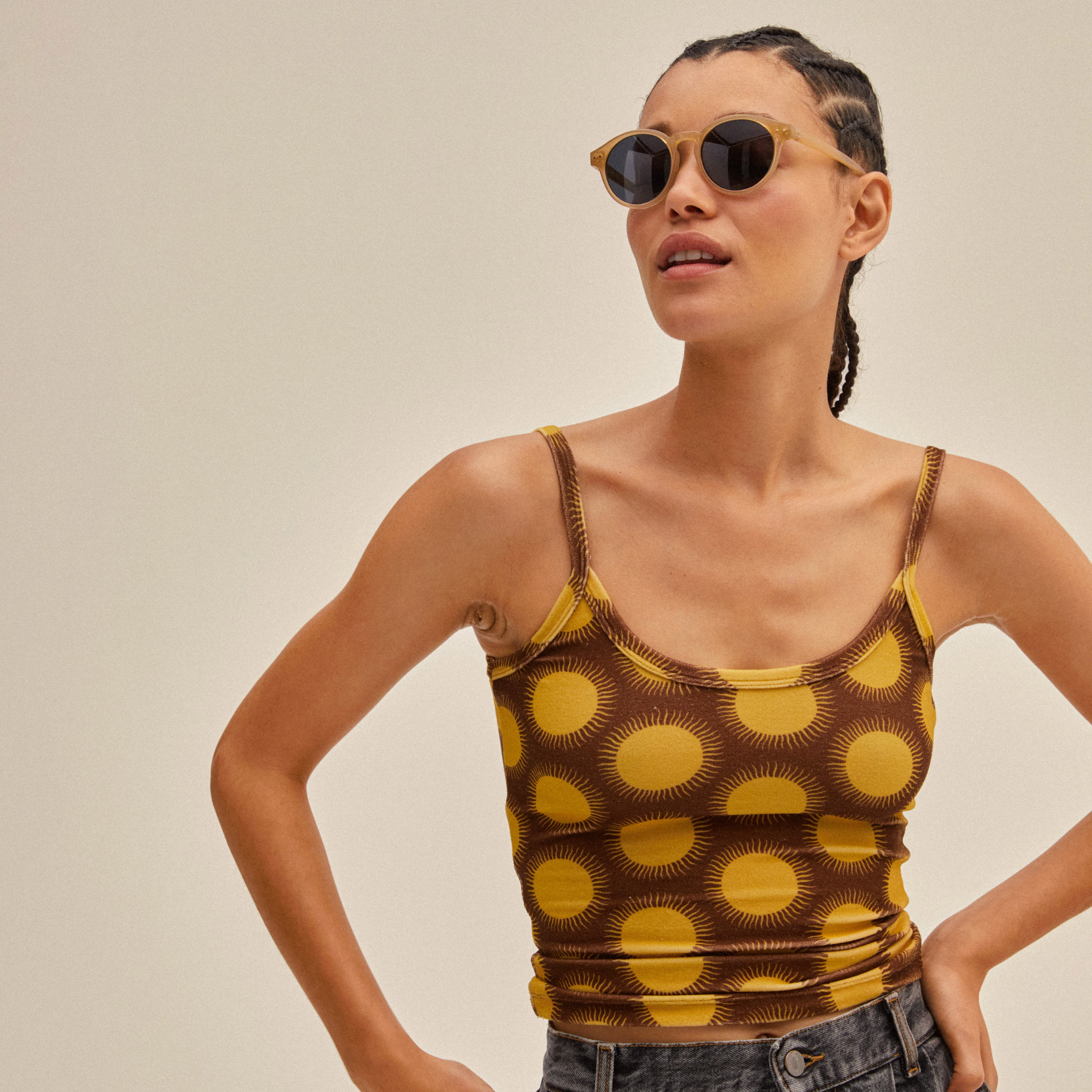 Woman wearing KYRIE sunglasses in light brown/gold with smoke-colored lenses, showcasing Pilgrim's Nordic-inspired design and sophisticated style.