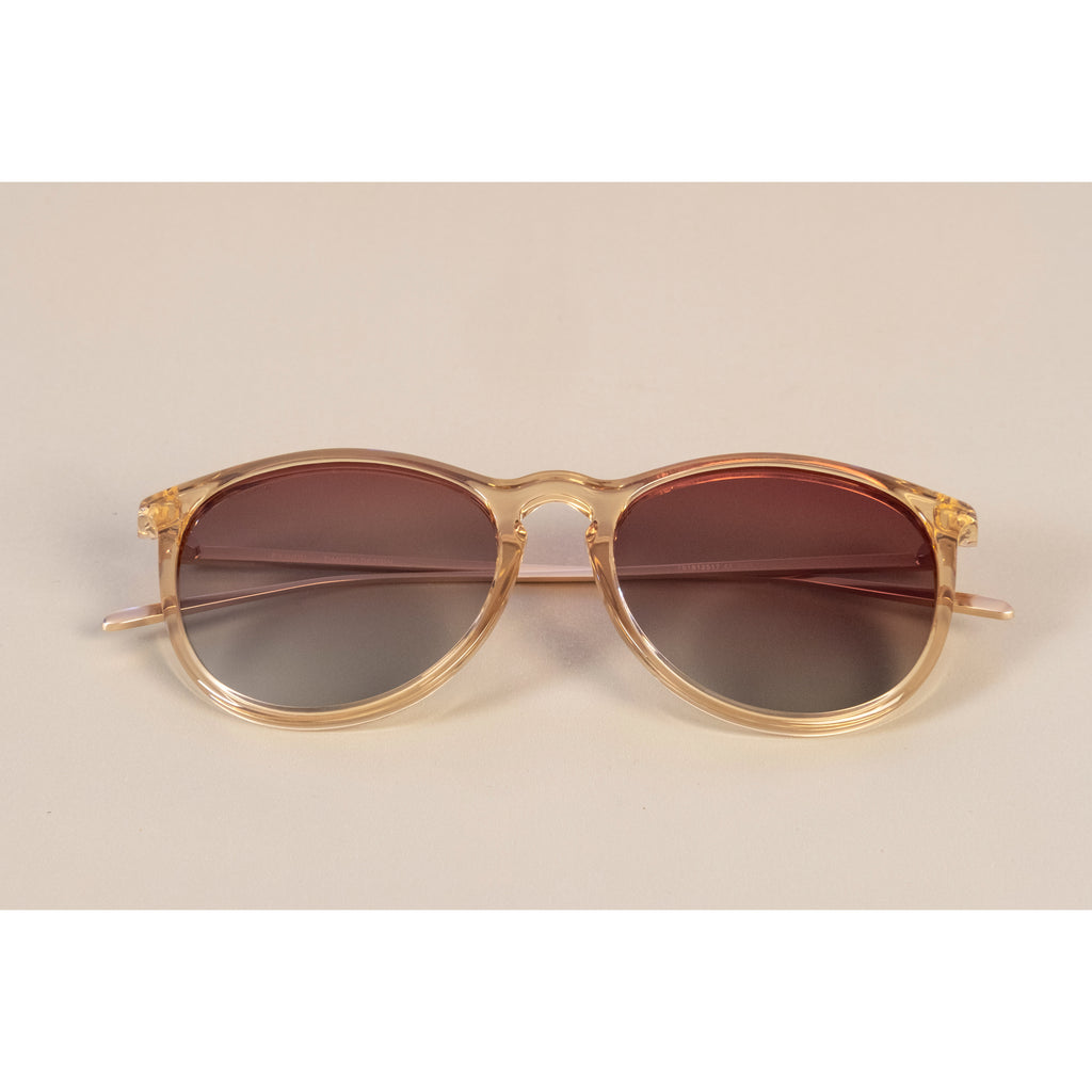 VANILLE sunglasses with slender metal temples and soft round lenses on a white surface, embodying Pilgrim's blend of timeless and trendy style.