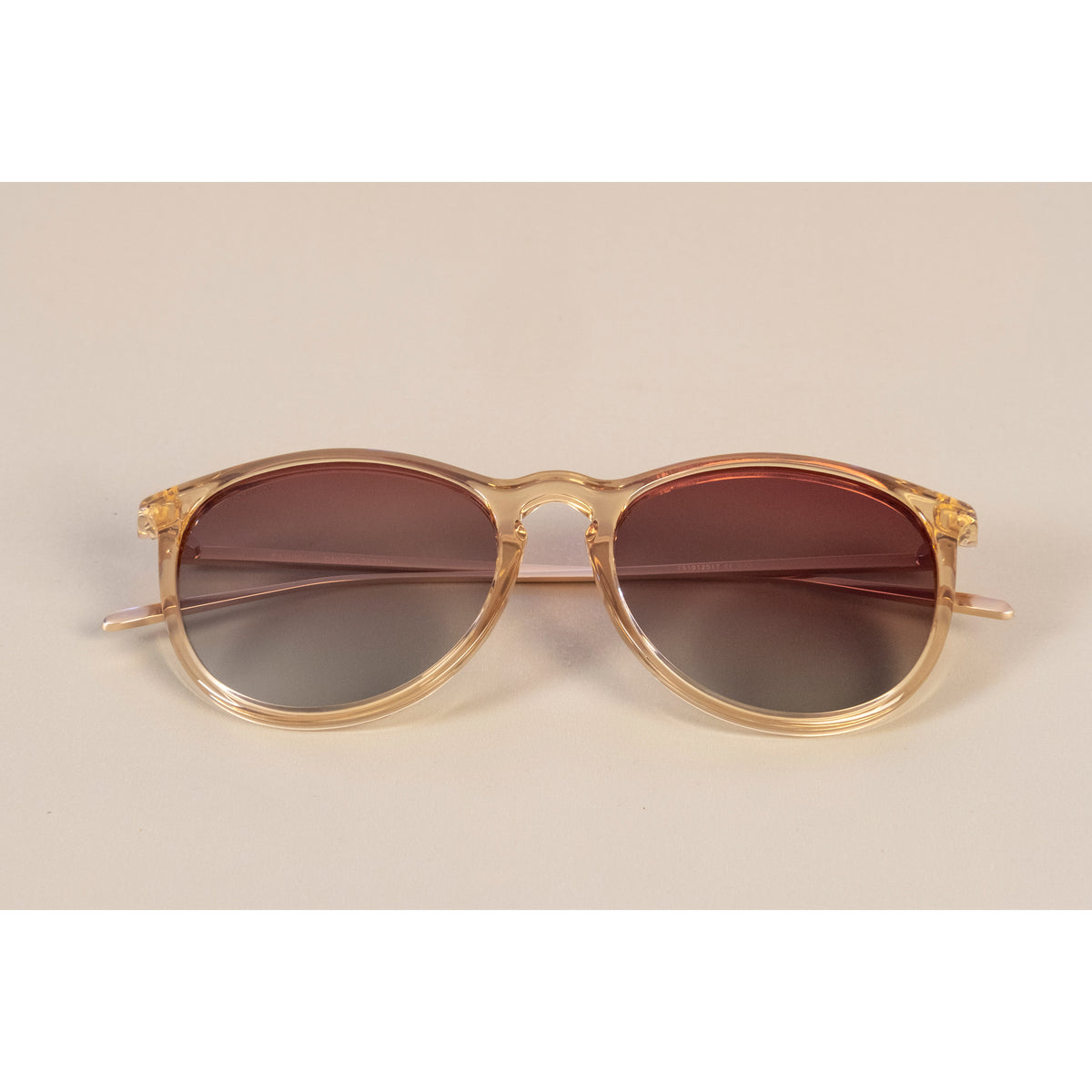 VANILLE sunglasses with slender metal temples and soft round lenses on a white surface, embodying Pilgrim's blend of timeless and trendy style.