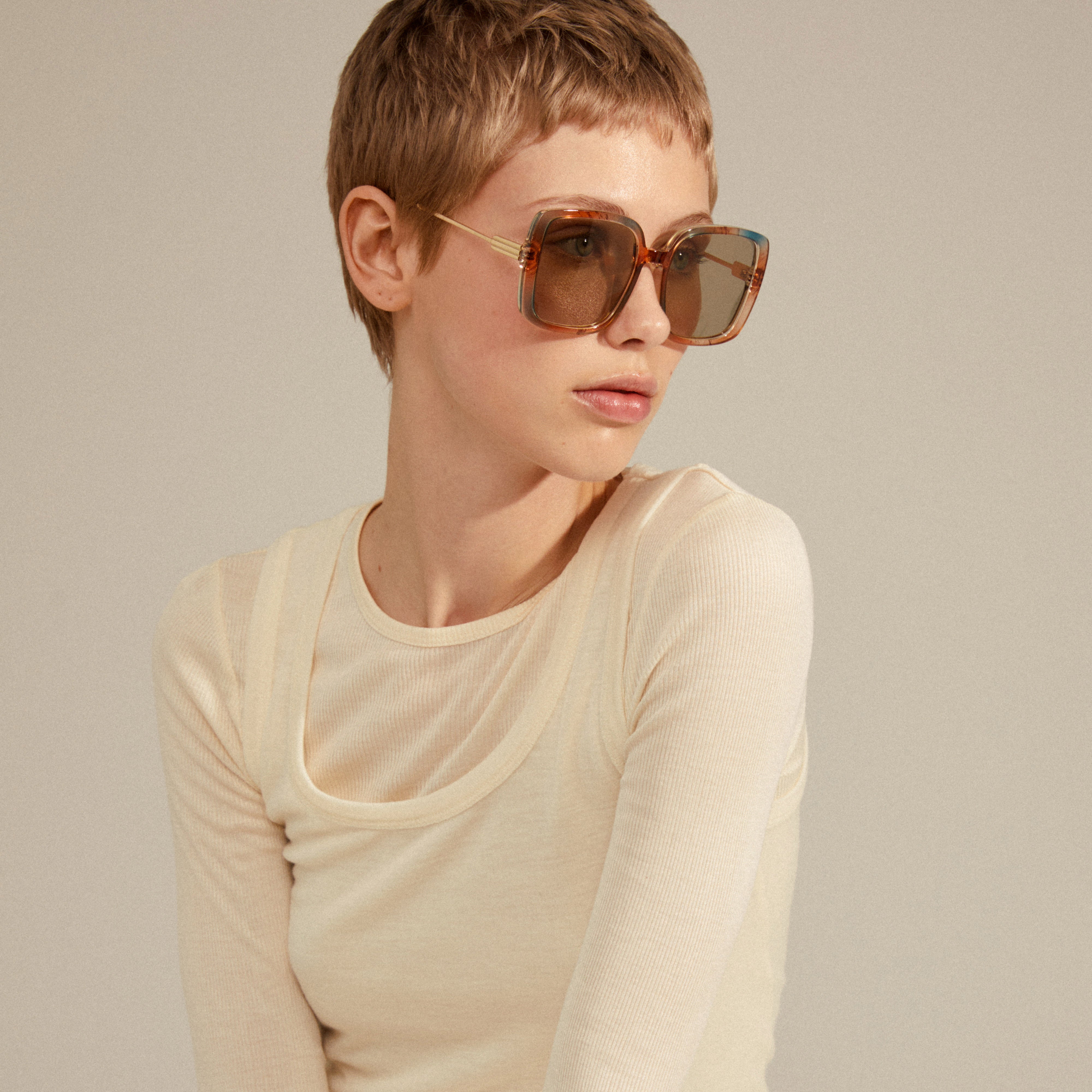 ALIET sunglasses multi/gold on a woman with short hair, showcasing oversized retro frames and golden temples, embodying a glamorous, vintage-inspired look.