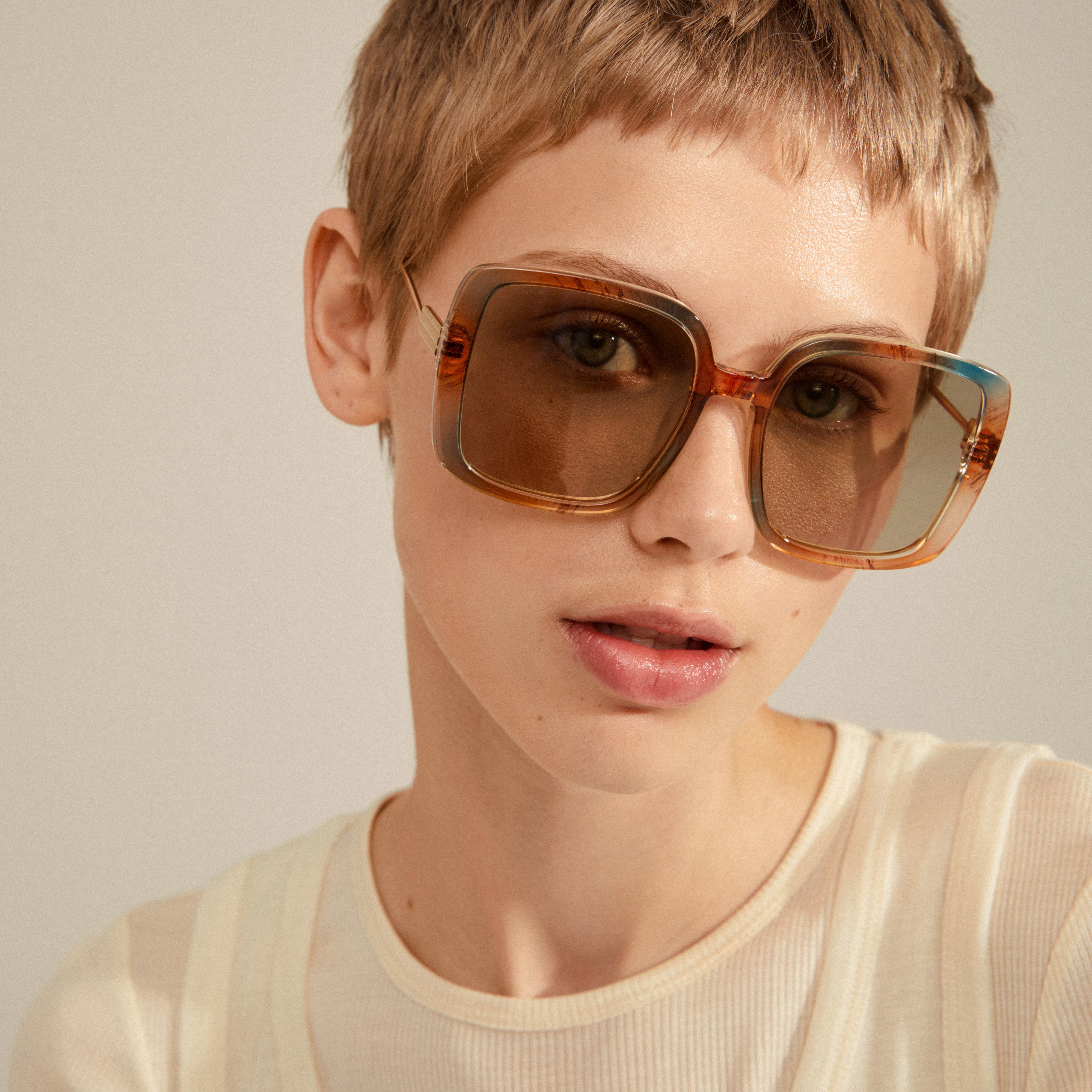 ALIET sunglasses multi/gold showcased on a woman with short hair, highlighting their oversized retro frames and golden temples, embodying a glamorous, vintage-inspired style.