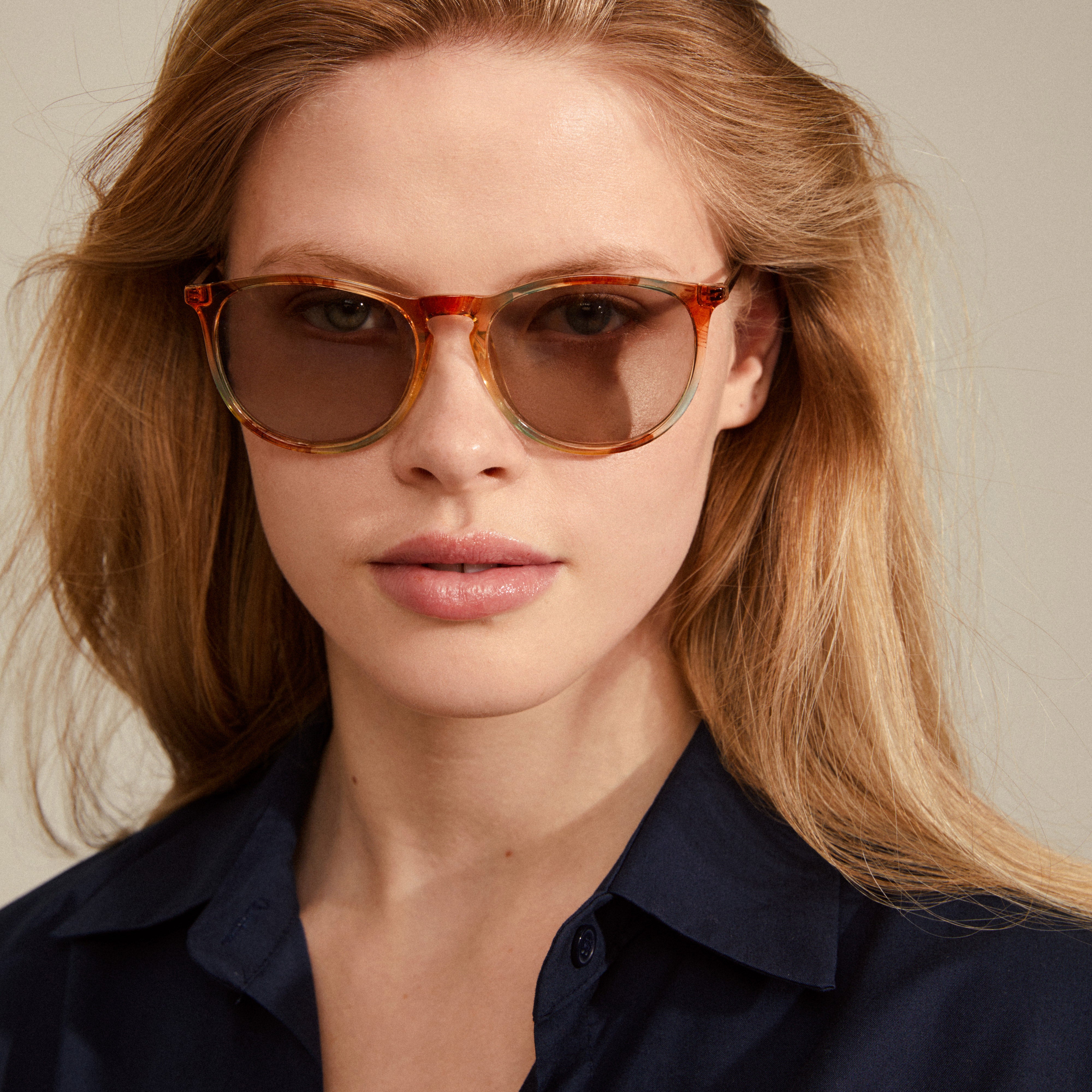 VANILLE sunglasses multi/gold, showcasing transparent light blue and orange frames with a classic, elegant shape, worn by a woman for a trendy, timeless look.