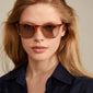 VANILLE sunglasses multi/gold, showcasing transparent light blue and orange frames with a classic, elegant shape, worn by a woman for a trendy, timeless look.
