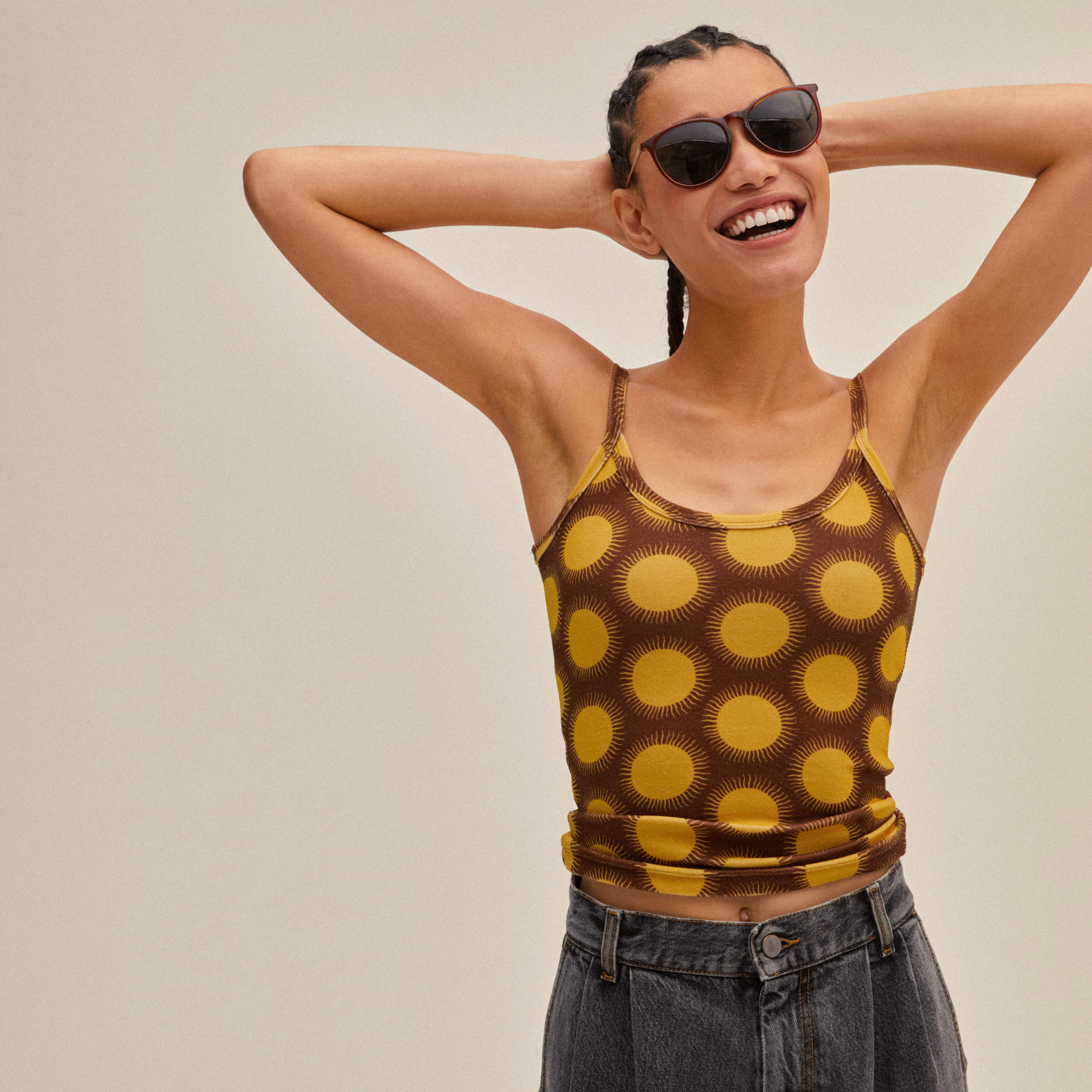 Woman wearing VANILLE sunglasses in dark brown/gold with sleek metal arms, embodying minimalist style, perfect for a summer-ready, fashionable look.