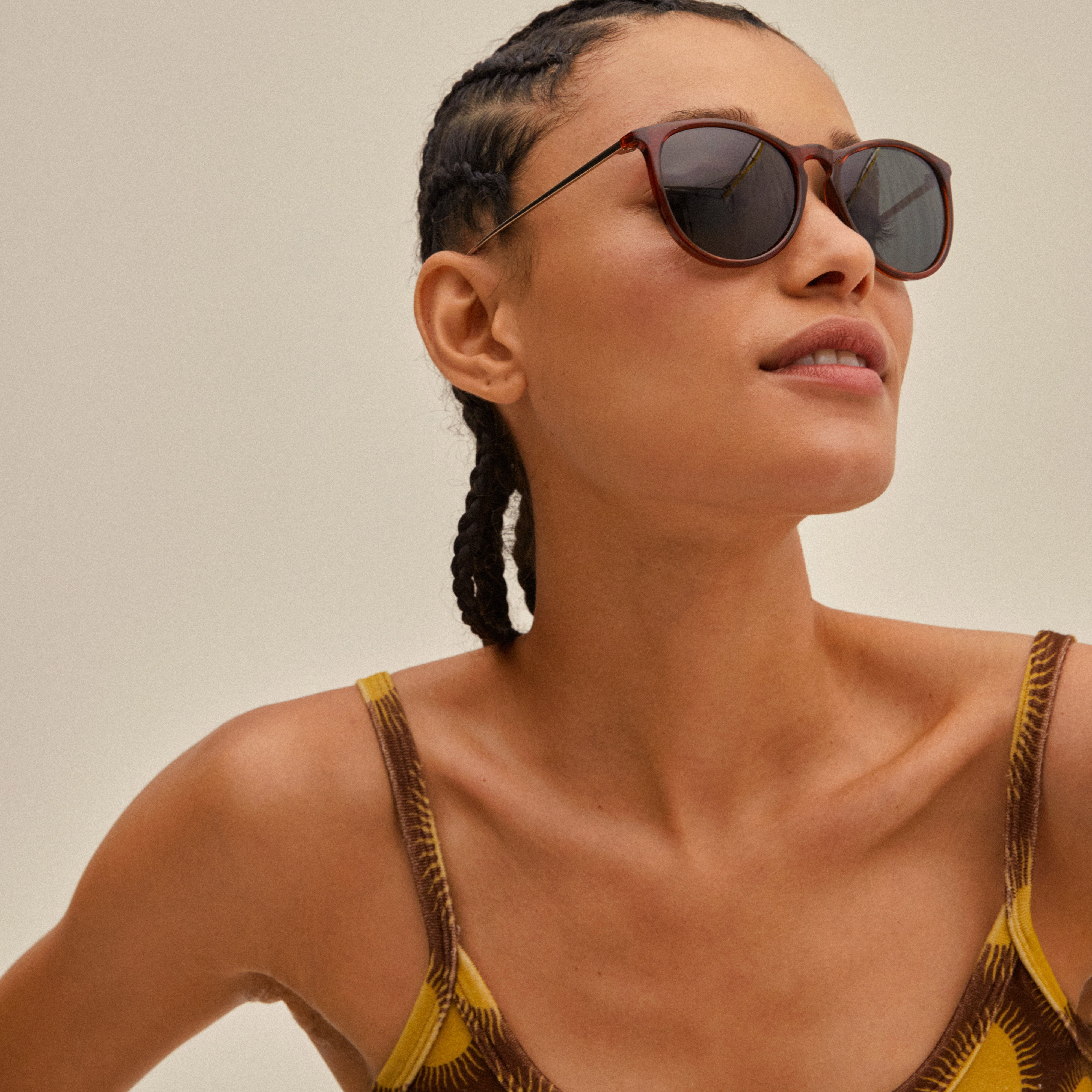 Woman wearing VANILLE sunglasses in dark brown/gold with sleek metal temples, showcasing Pilgrim's high-class summer accessory.