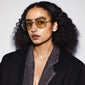 Woman wearing Pilgrim's DALLAS sunglasses in yellow/gold, showcasing a classic pilot style. The sunglasses offer UVA/UVB protection, perfect for adventurous, trendsetting fashion.