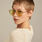 DALLAS sunglasses yellow/gold on woman with short hair, showcasing iconic pilot style and UVA/UVB protection, embodying Pilgrim's adventurous spirit.