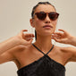 Woman wearing sunglasses with PAOLA chain for sunglasses, silver-plated, showcasing its elegant cable-chain style, enhancing her chic look.