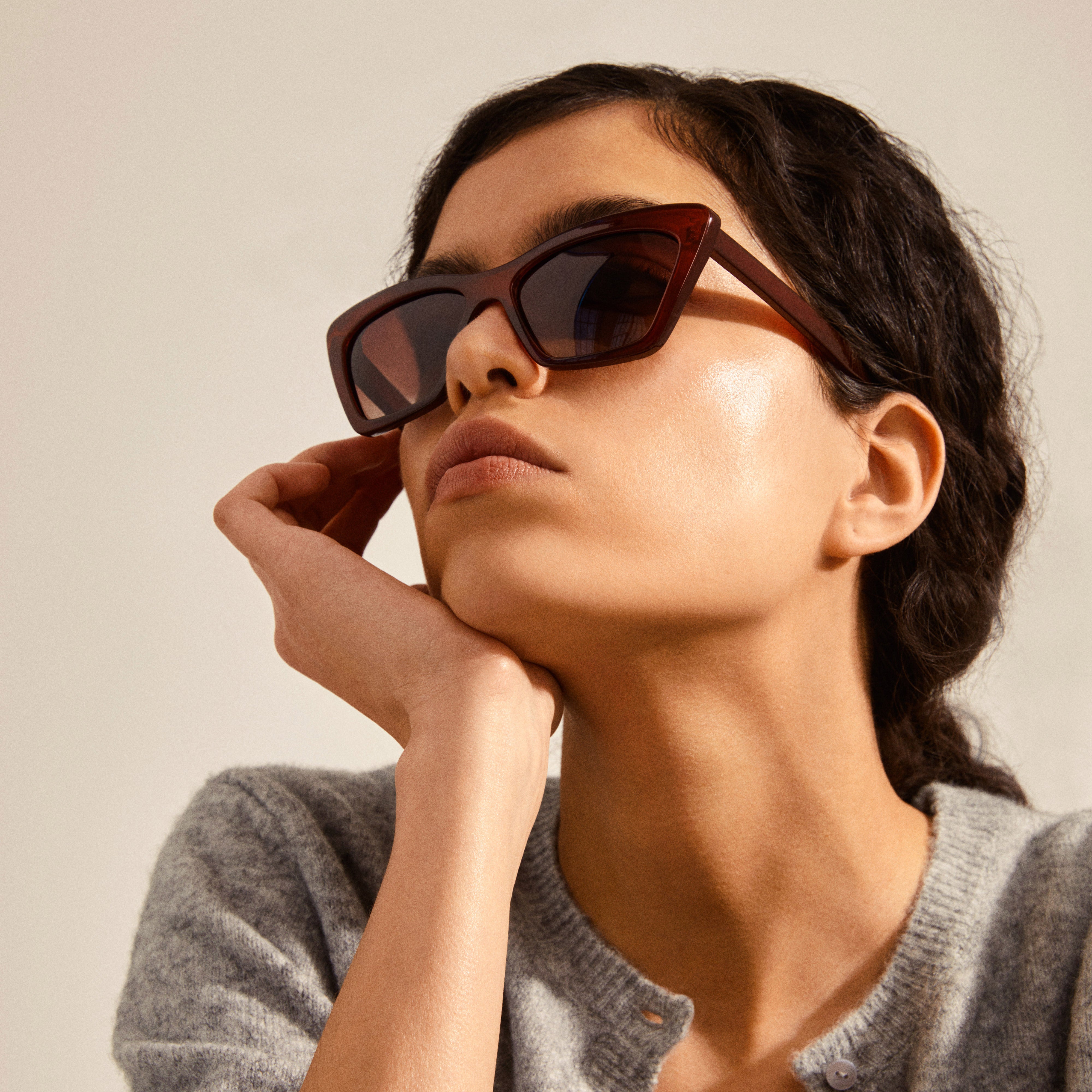 Woman wearing DAKOTA angular cat-eye shaped sunglasses, showcasing their bold design and feminine style, perfect for enhancing cheekbones and adding glam to spring looks.