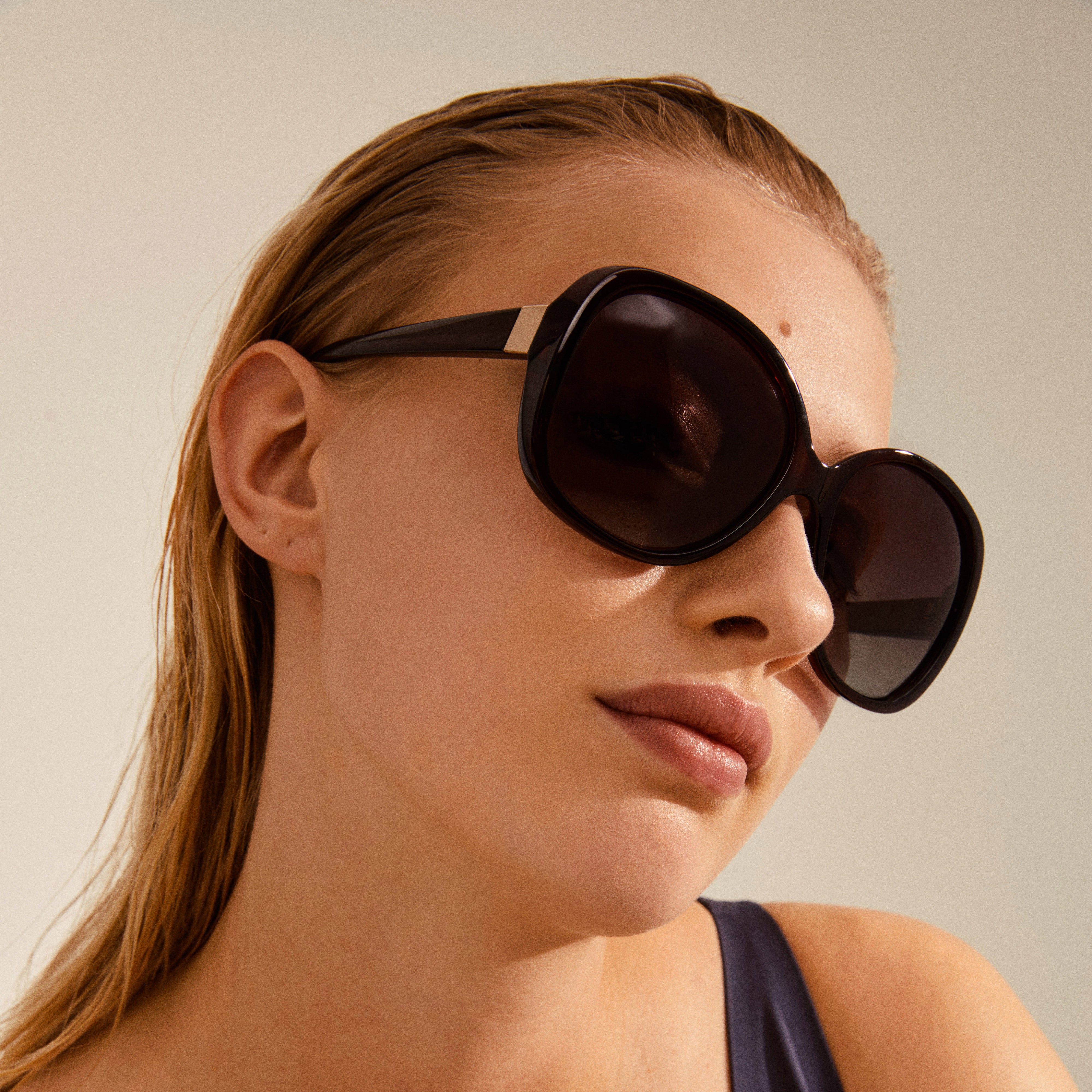 Woman wearing PARKER oversized retro sunglasses, featuring a vintage-inspired design with graduated brown lenses, embodying a glamorous, timeless style.