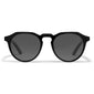 ALEJANDRA sunglasses by Pilgrim feature a modern angular frame with black lenses, offering a stylish twist on classic round designs, complete with UVA/UVB protection.