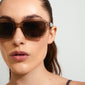 ANNALISE sunglasses light grey worn by a woman, featuring an angular transparent smoky frame with matching lenses, ideal for summer outings.