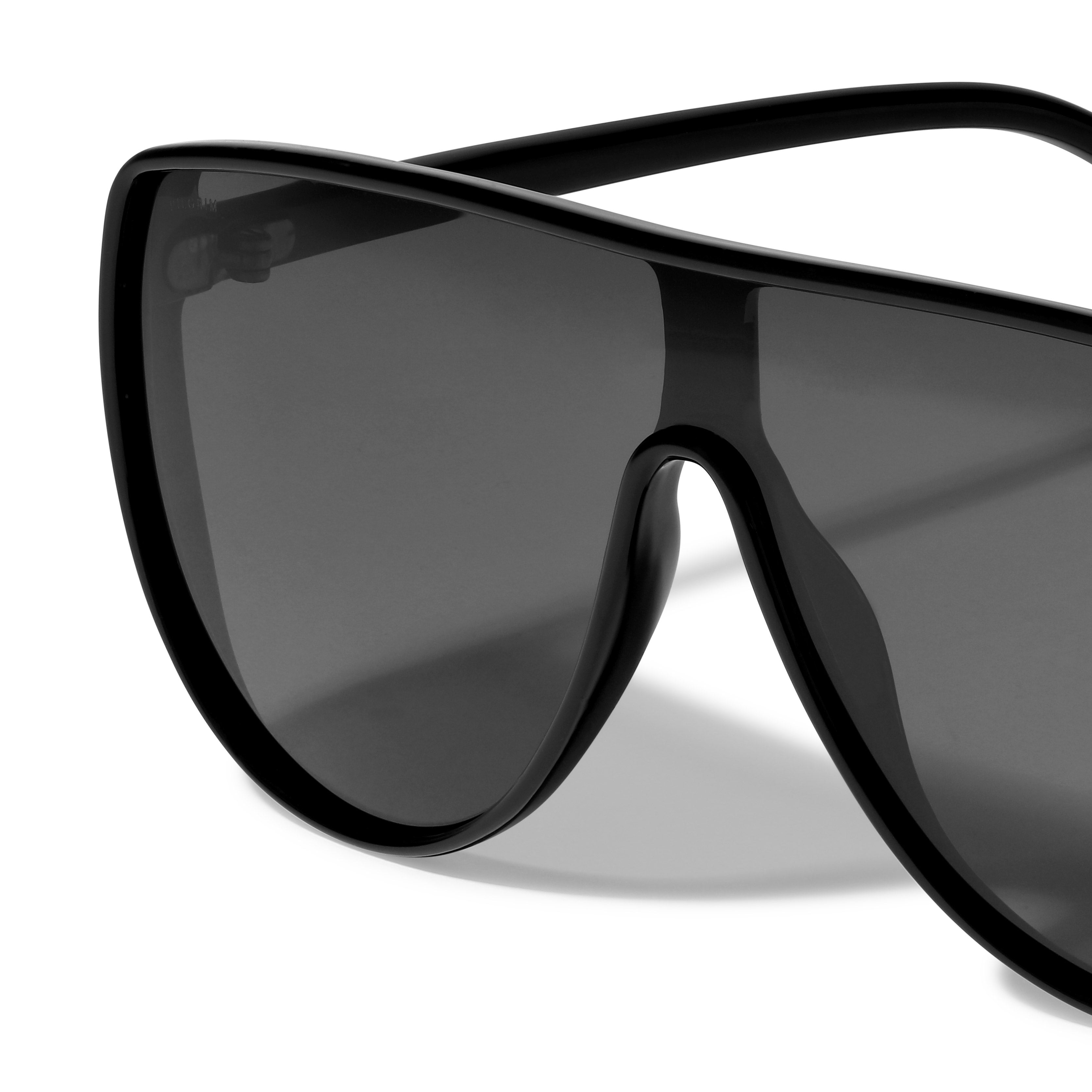 Close-up of black AMARI sunglasses with oversized dark lenses, embodying urban style and confidence from Pilgrim.